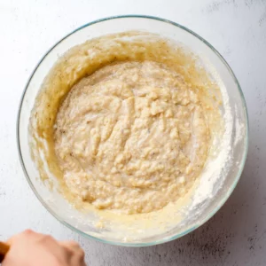 Sift in the flour and baking powder and using a rubber spatula, fold into the banana mixture until a few flour streaks remain
