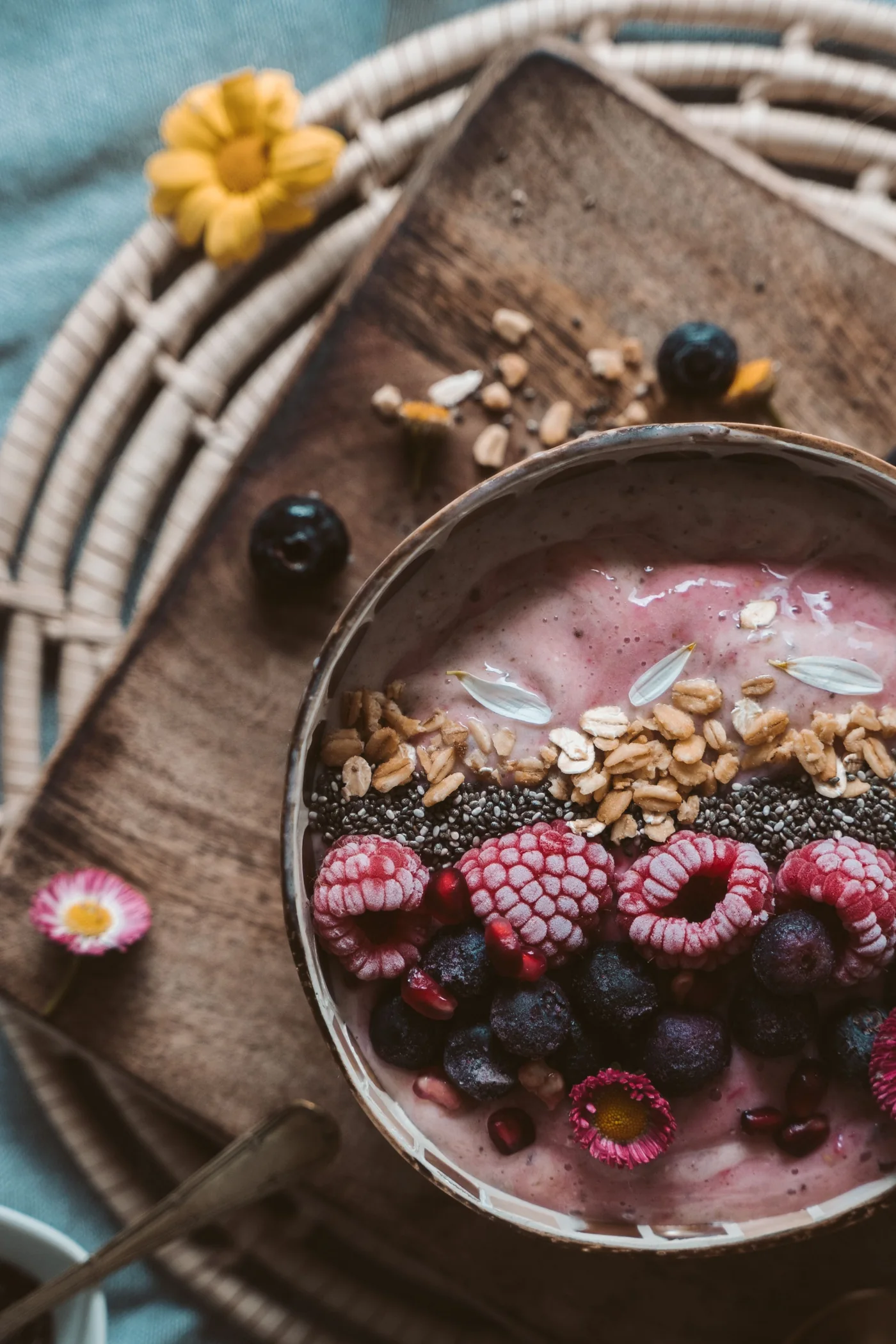 Close-up of a dark berry smoothie bowl with raspberries, blueberries, chia and granola