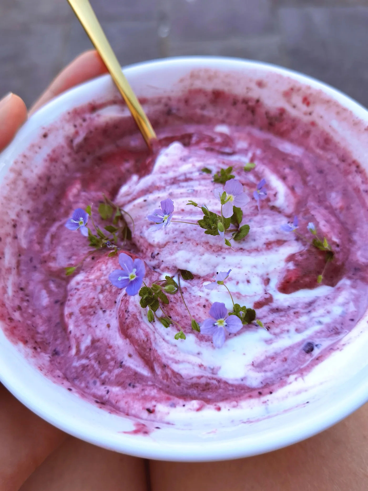 Swirled black forest smoothie bowl with yogurt and edible flowers