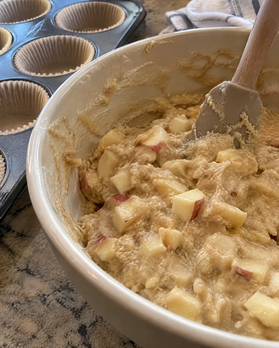 Thick apple muffin batter in a mixing bowl