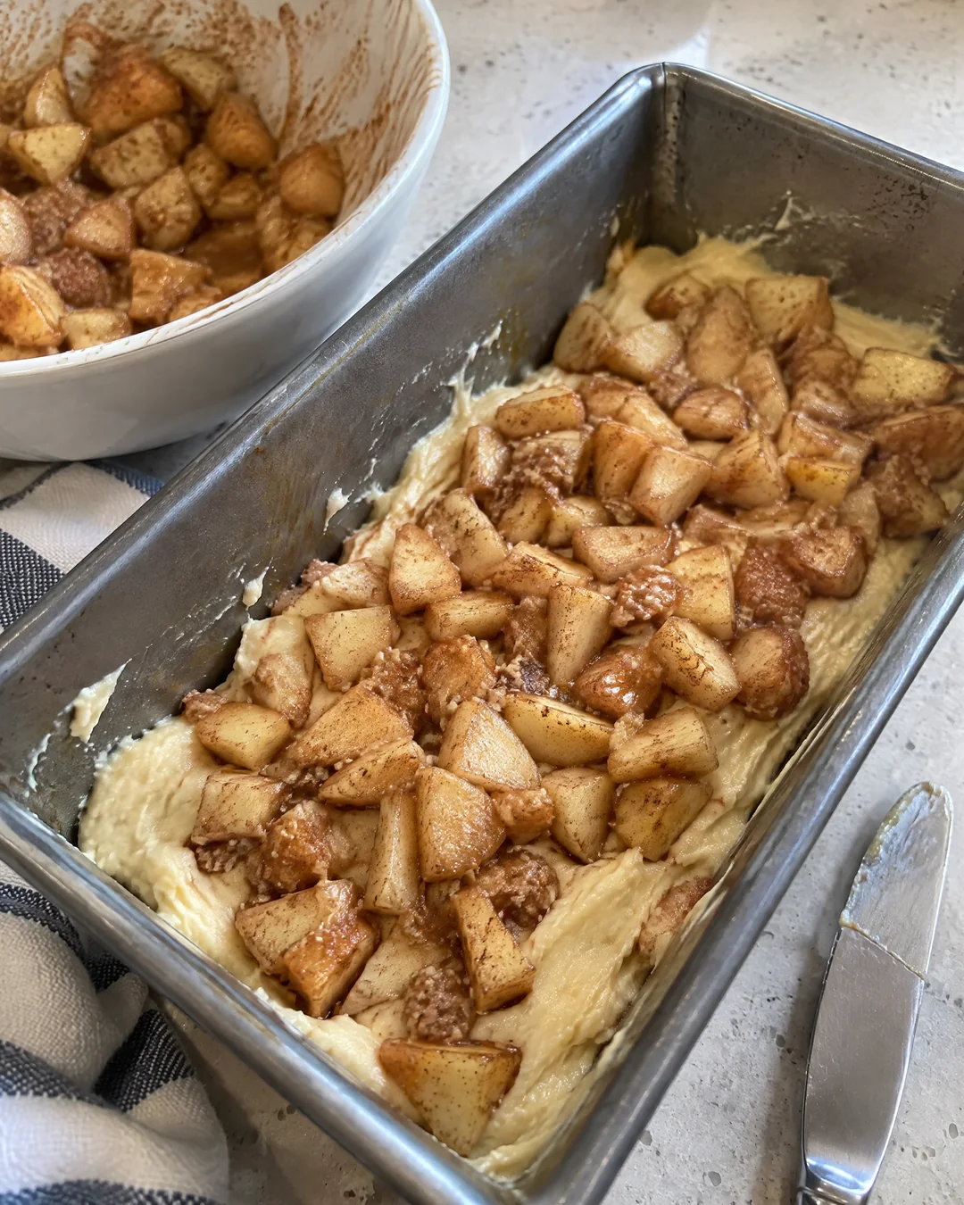 Chopped apples tossed in brown sugar and cinnamon layered into apple fritter bread batter