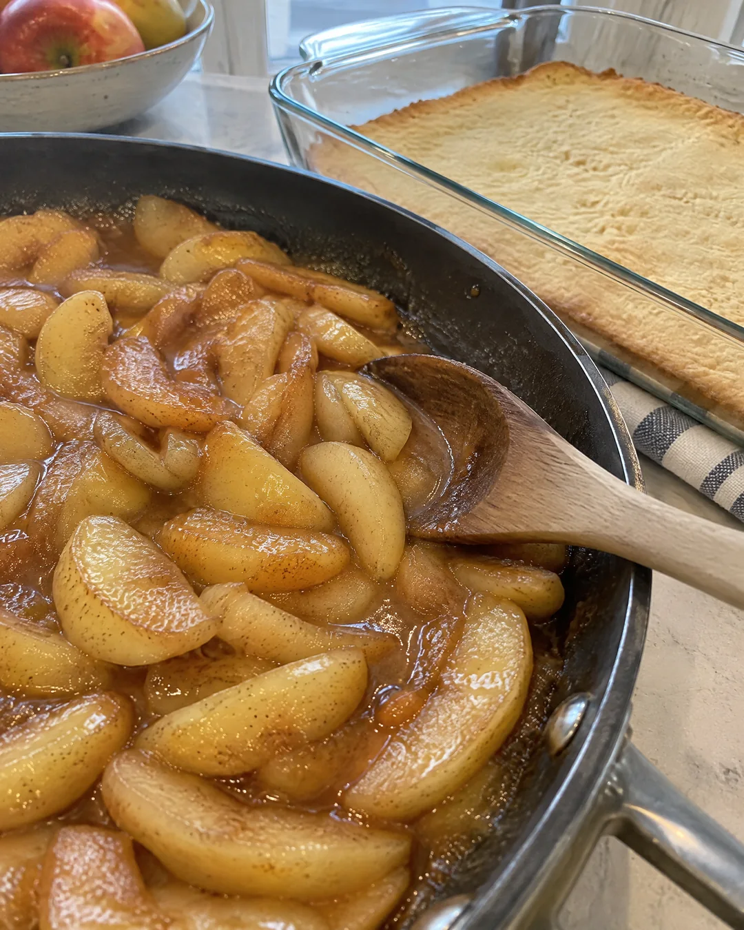 Cinnamon apple slices cooking in a skillet for apple pie bars