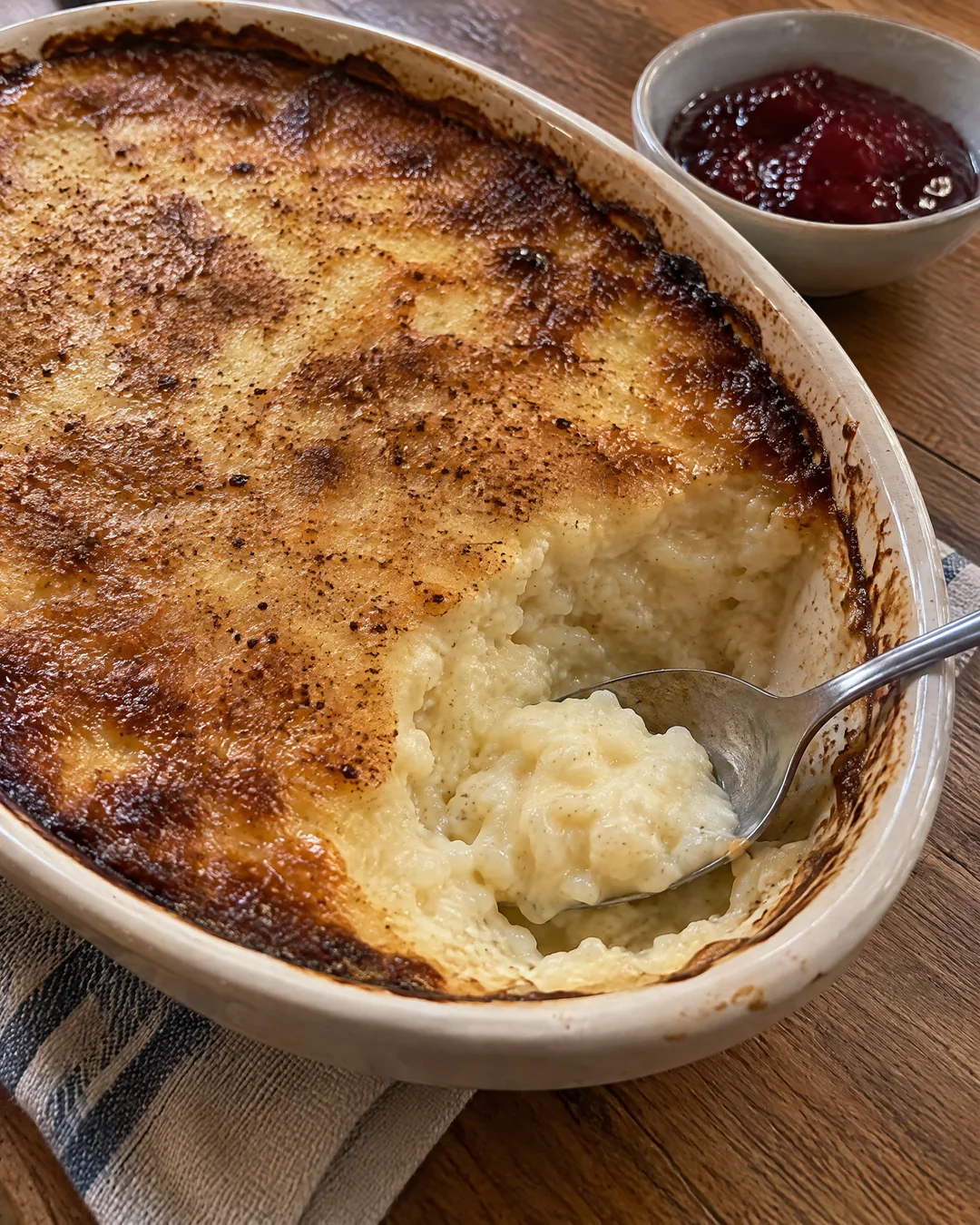 Baked rice pudding with a golden brown skin, a spoonful lifted out