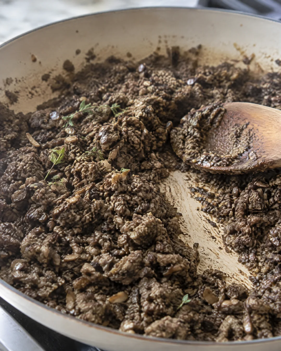 Dry mushroom duxelles in a skillet