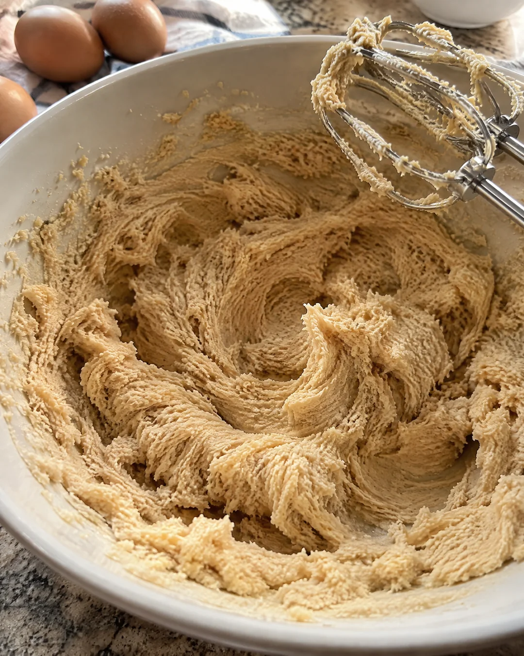 Pale fluffy creamed butter and brown sugar in a mixing bowl