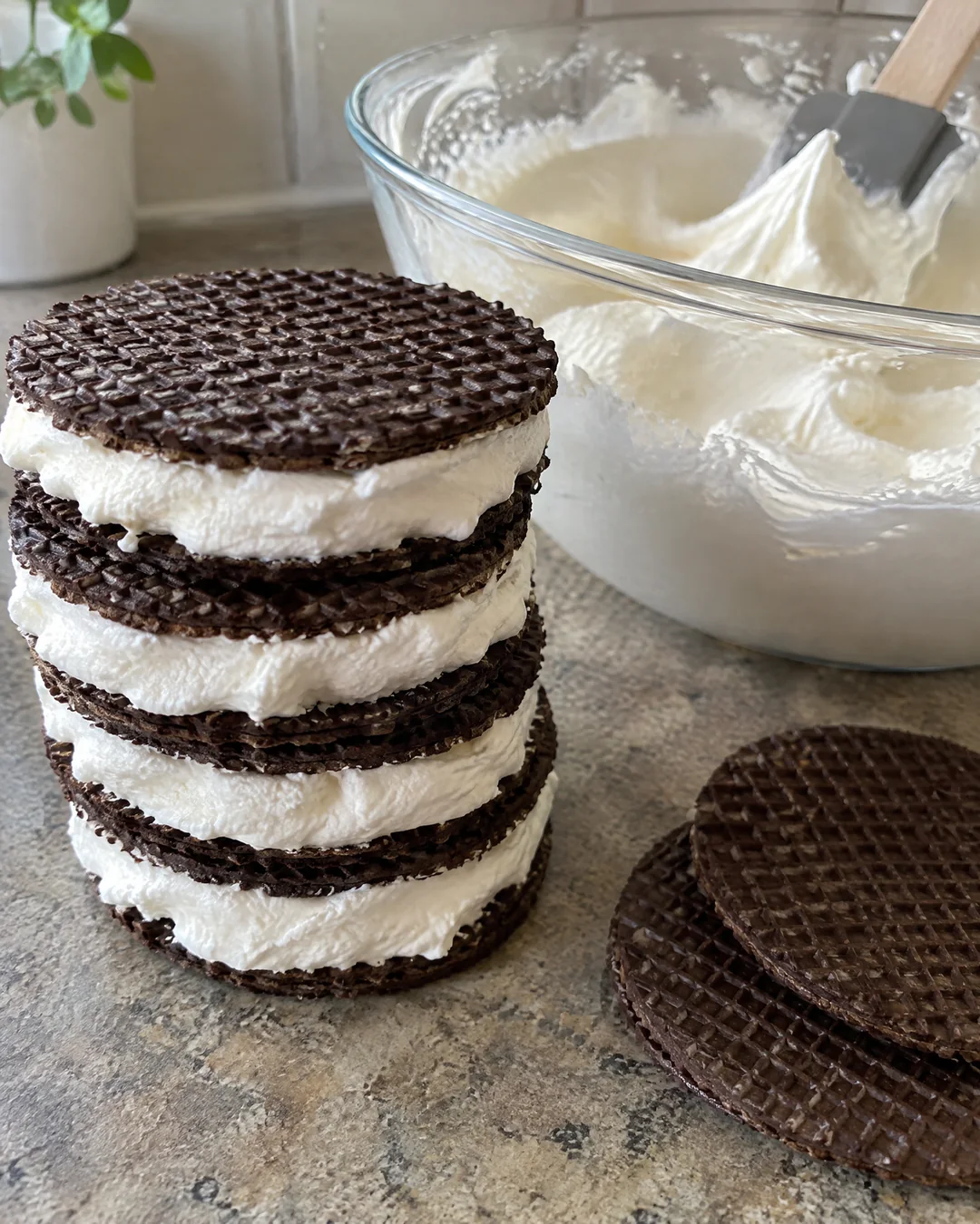 Stacking chocolate wafers with whipped cream for an icebox cake