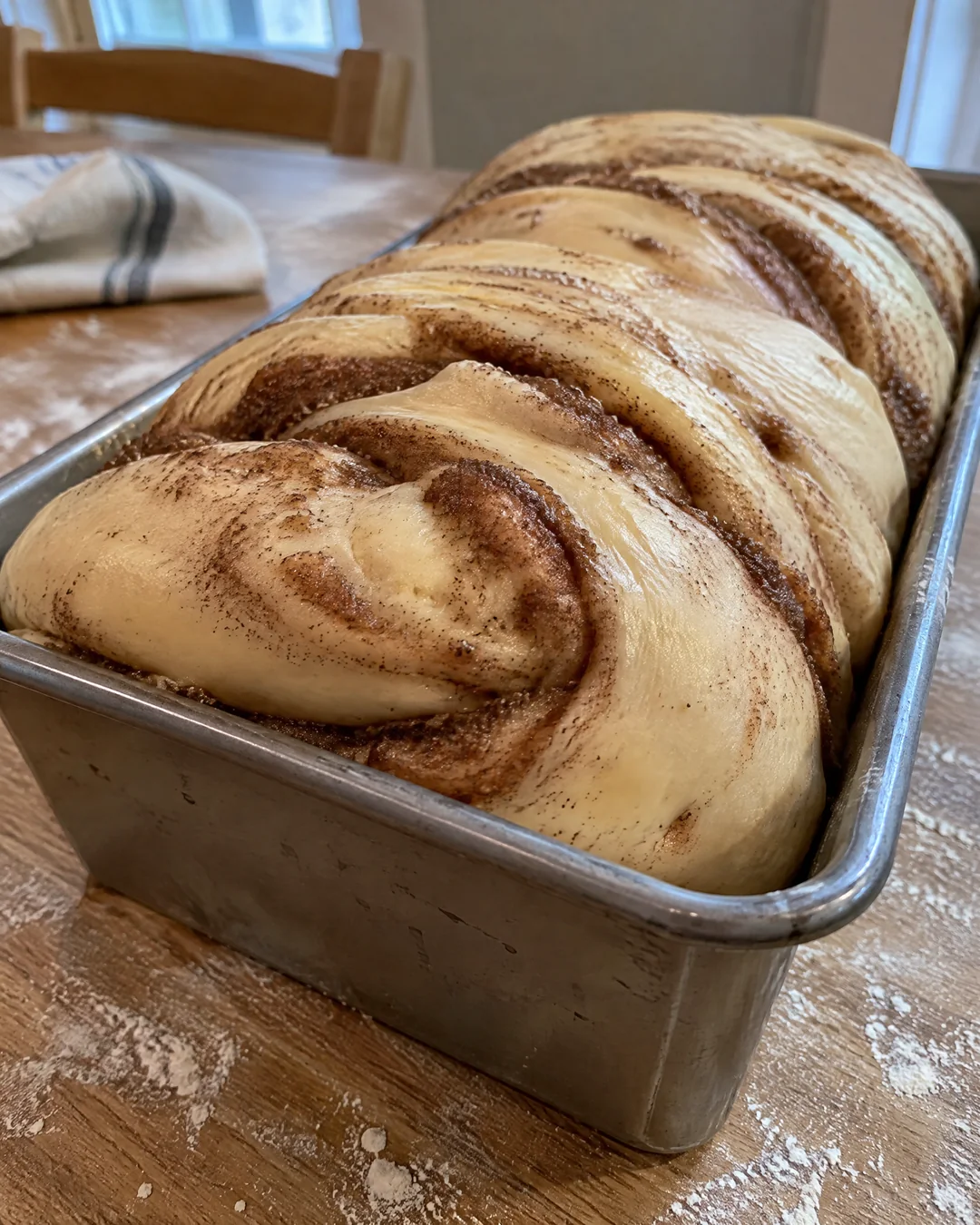 Cinnamon swirl bread risen above the loaf pan