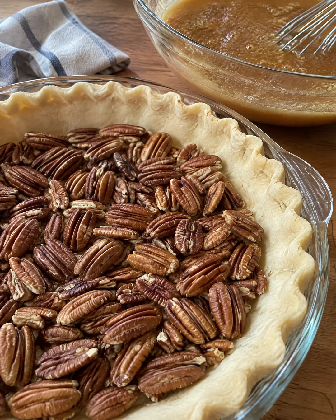 Whole pecan halves spread in an unbaked pie crust before the filling goes in