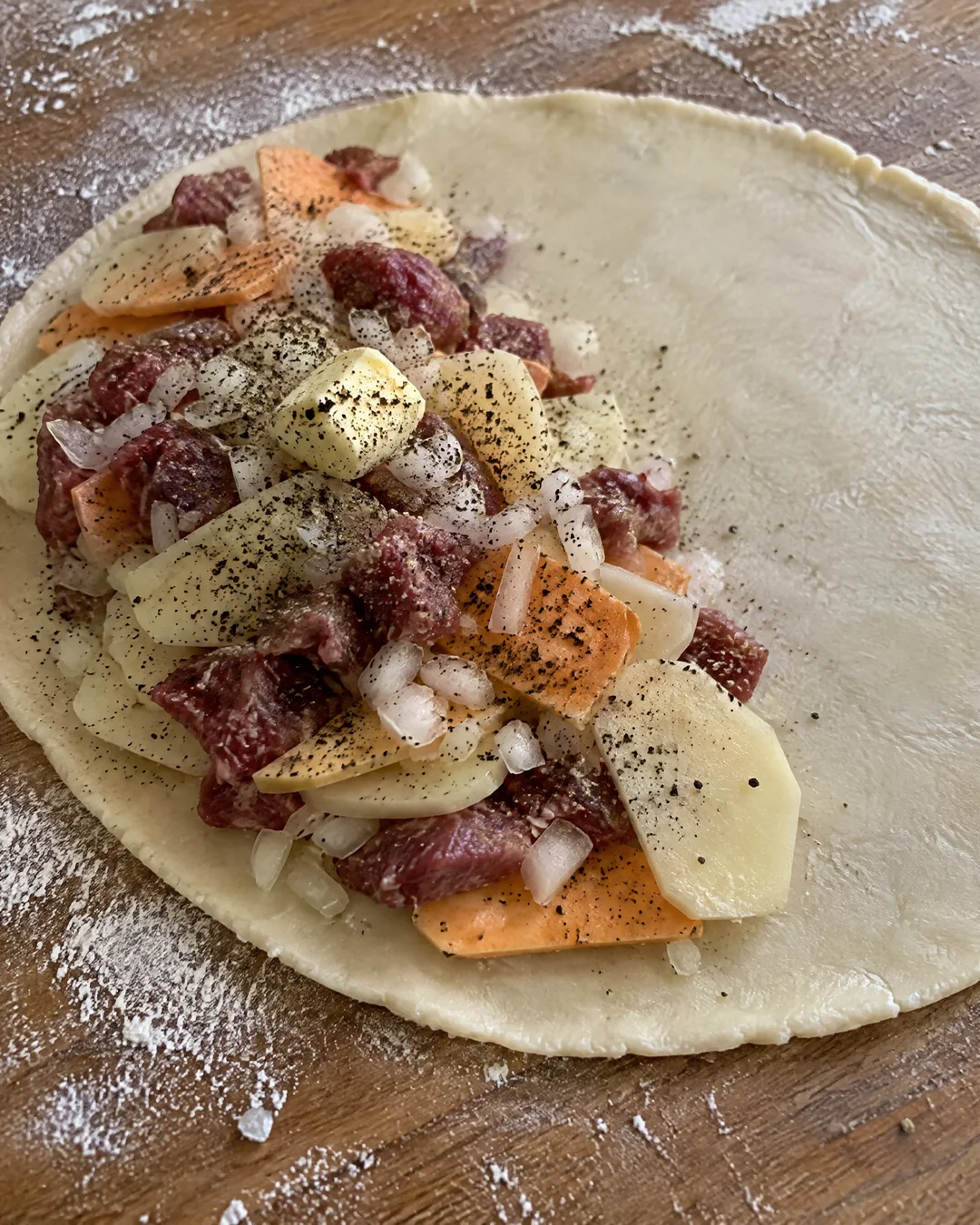 Raw beef, potato, swede and onion layered on a circle of pastry for a Cornish pasty