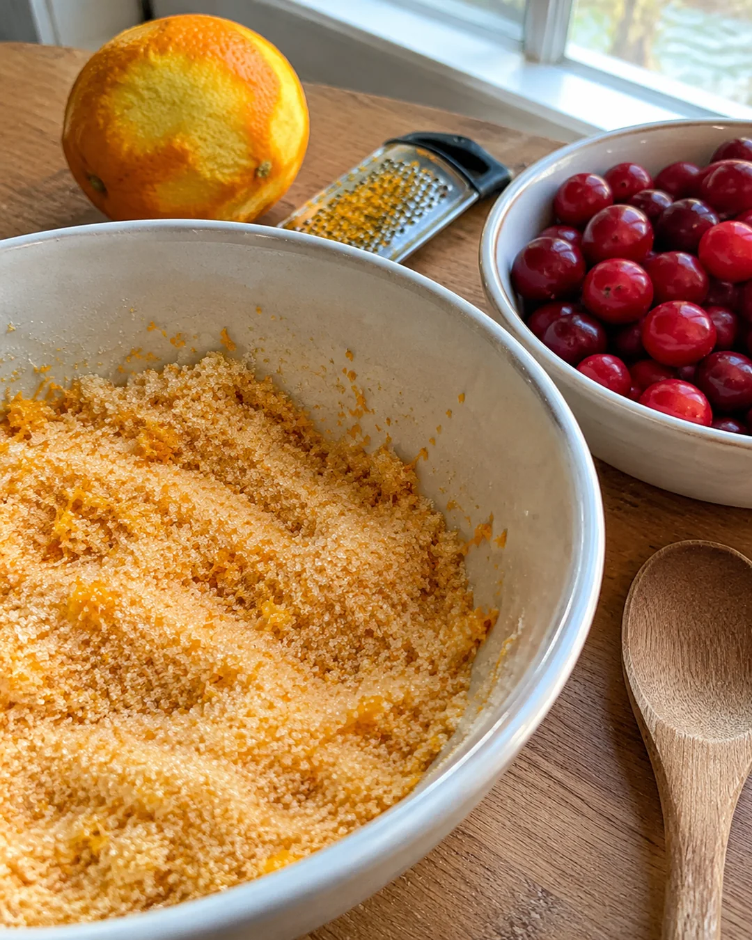 Rubbing orange zest into sugar for cranberry orange bread