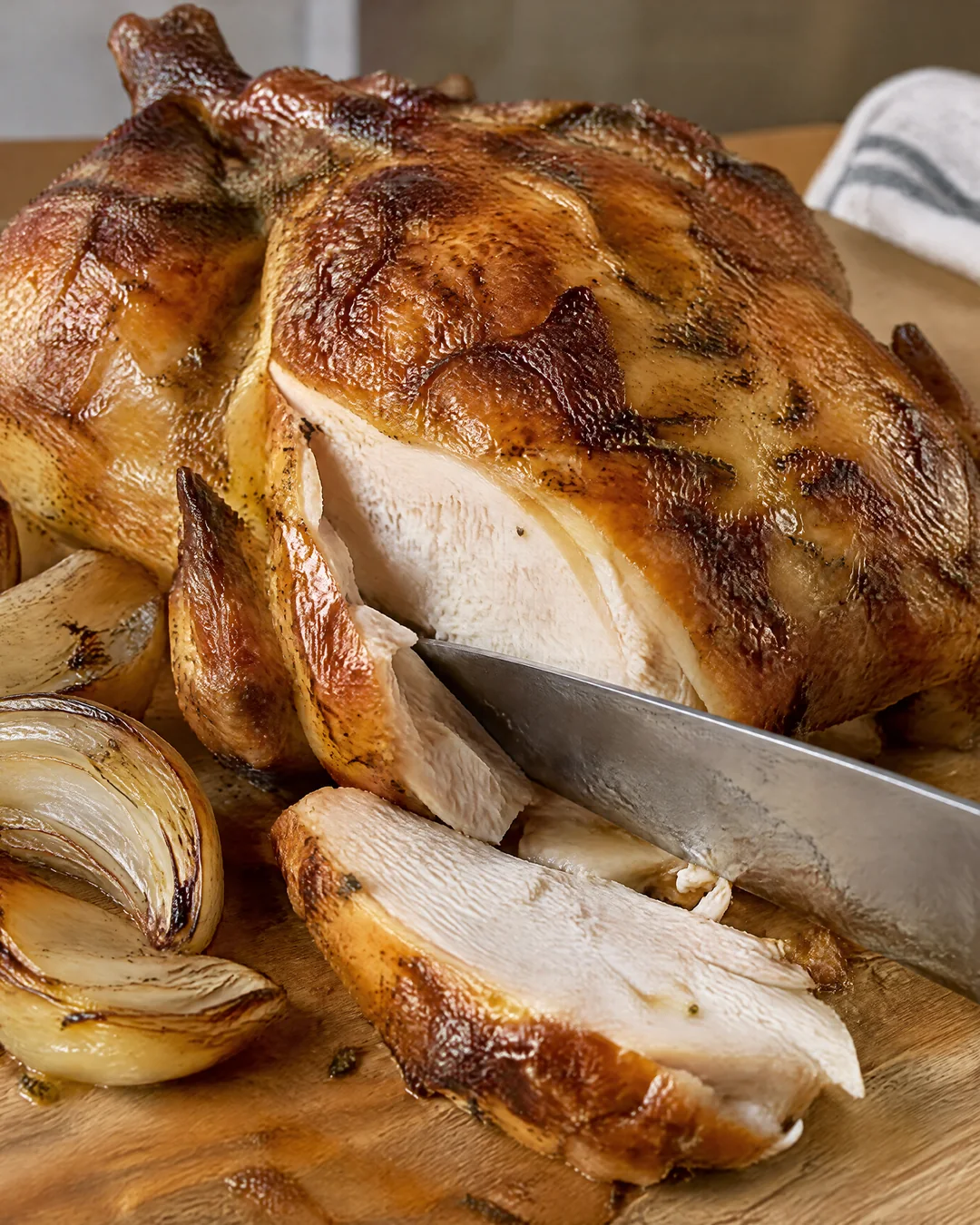 Roast chicken being carved on a board, crackling golden skin
