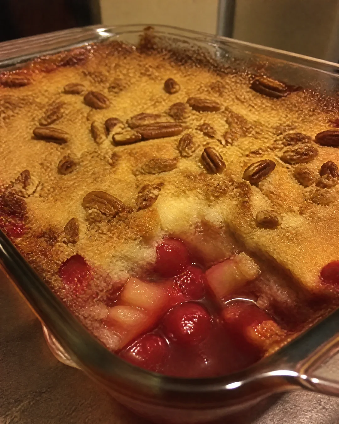 A baked cherry pineapple dump cake with a golden crisp top and bubbling fruit