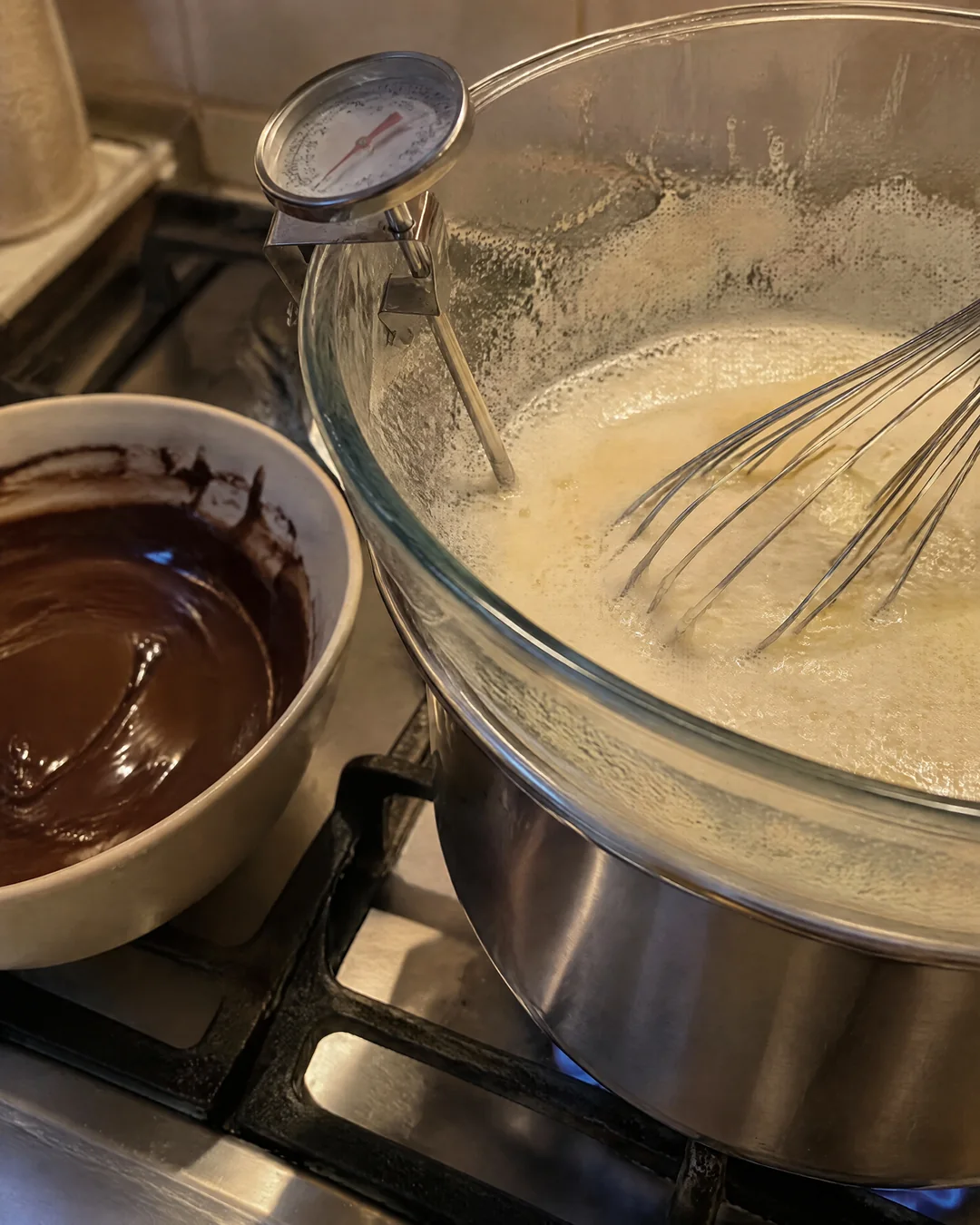 Eggs and sugar being whisked over simmering water