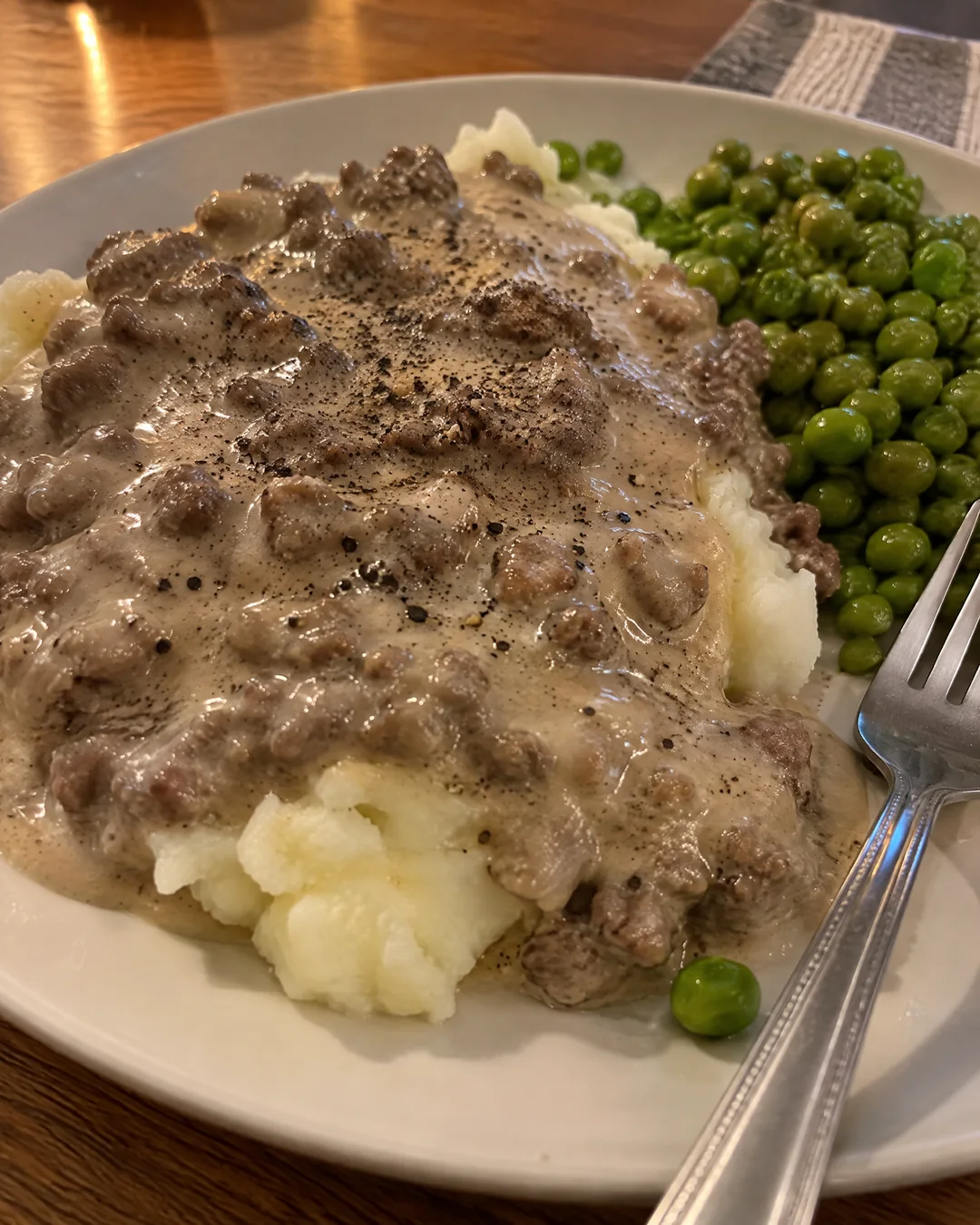 Hamburger gravy ladled over mashed potatoes