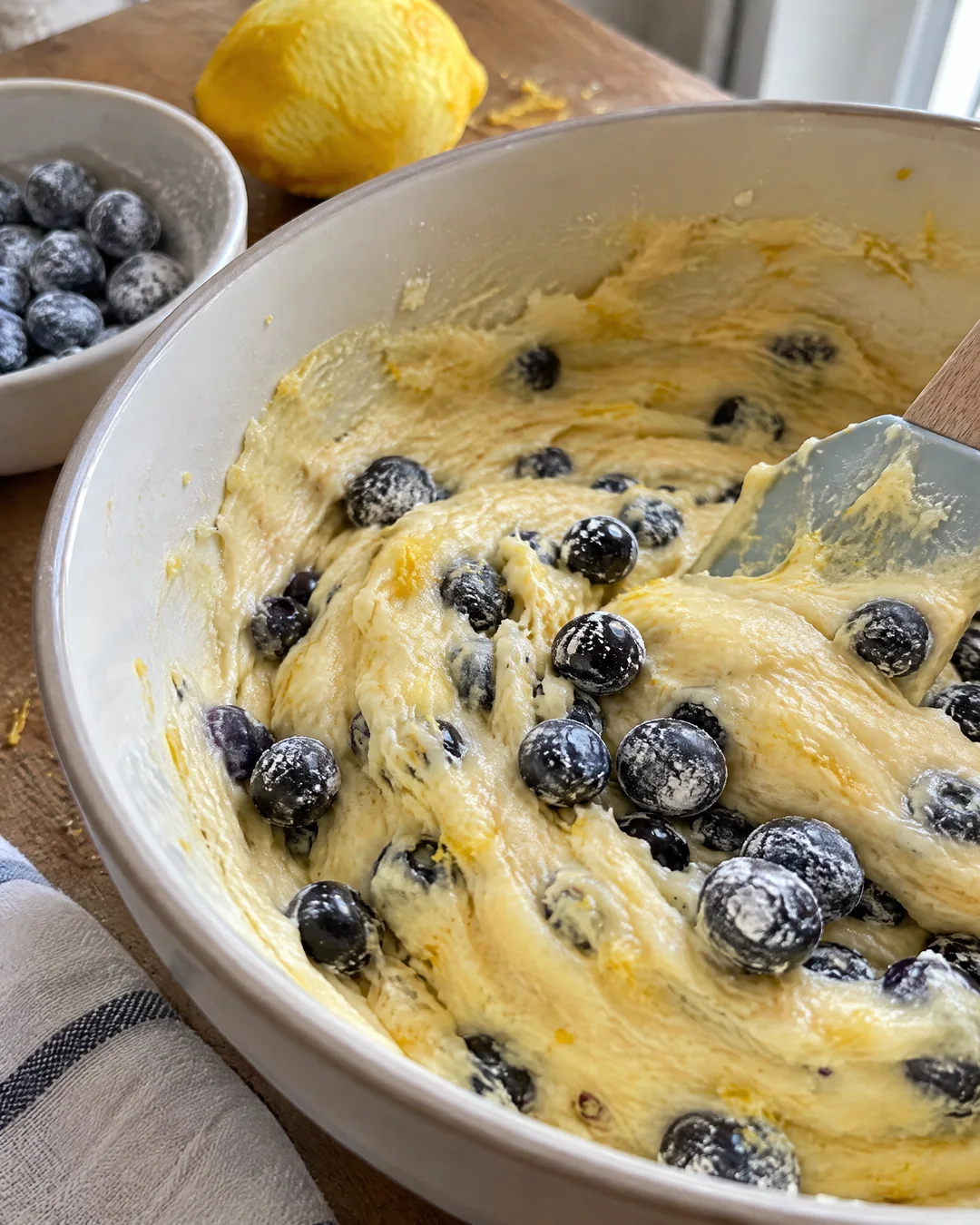 Floured blueberries being folded into lemon batter