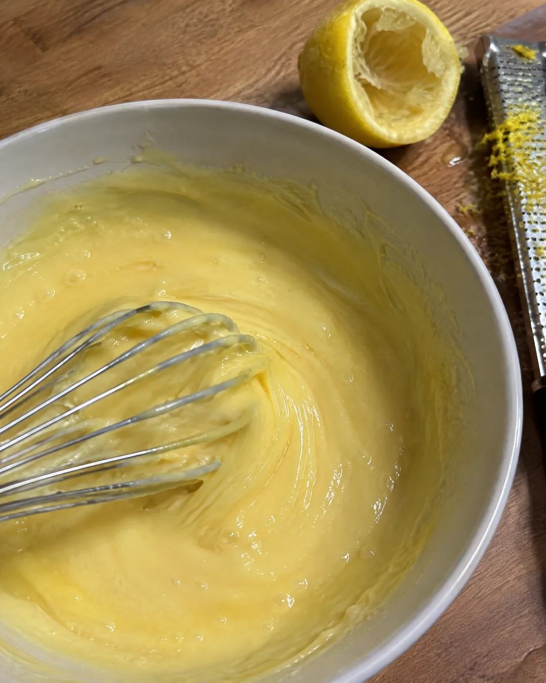Whisking lemon juice into sweetened condensed milk and egg yolks until it thickens