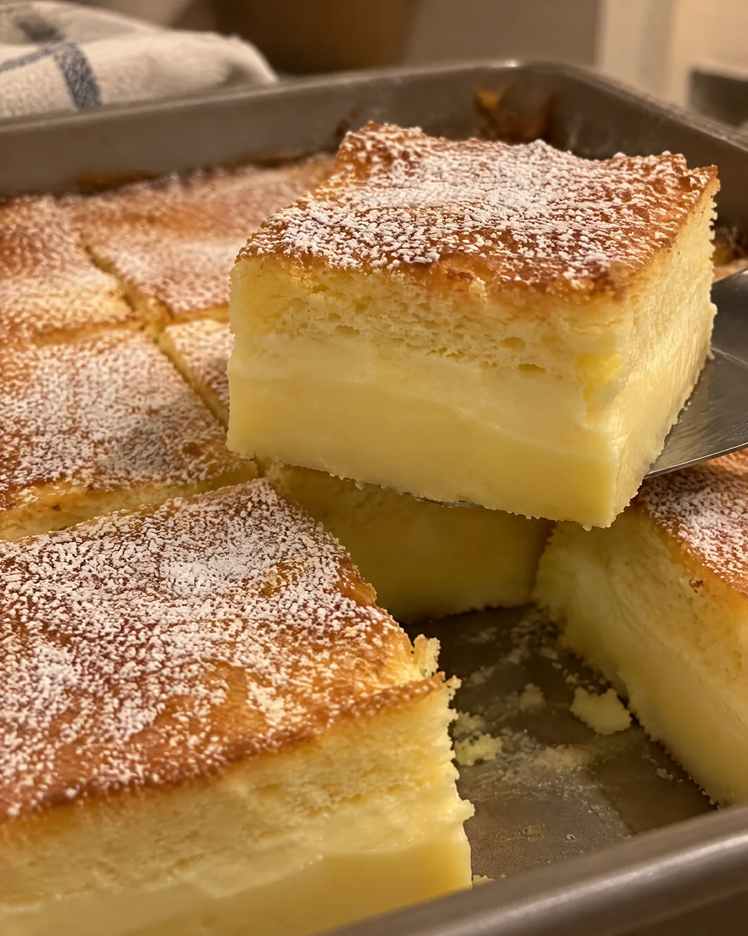 Magic custard cake squares showing three layers