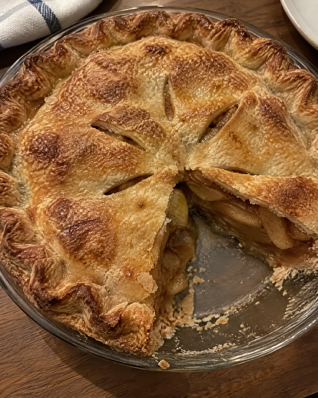 A whole golden double-crust mock apple pie seen from above with one slice removed, showing the amber cinnamon filling