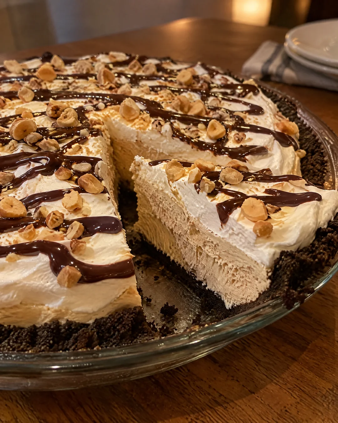 Whole no-bake peanut butter pie with chocolate drizzle and chopped peanuts