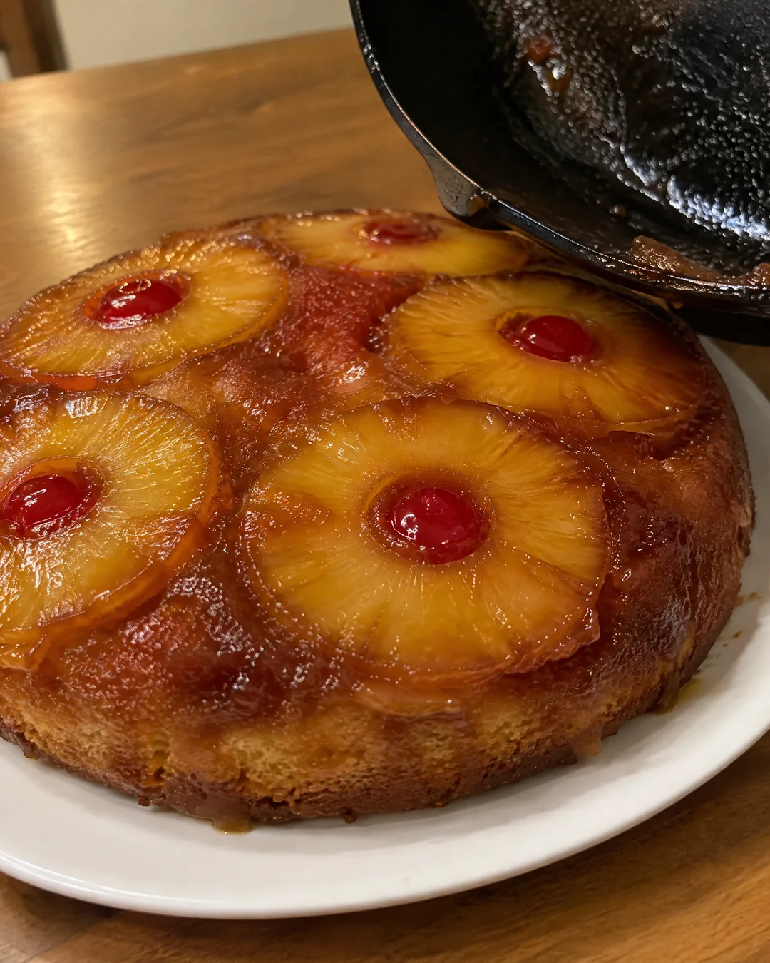 Flipping the pineapple upside-down cake out of the skillet onto a plate
