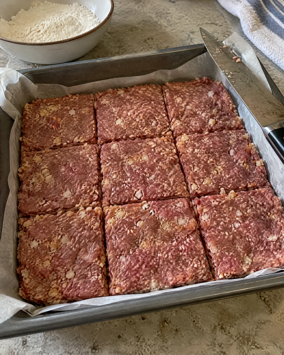 Ground beef and cracker mixture pressed into a pan