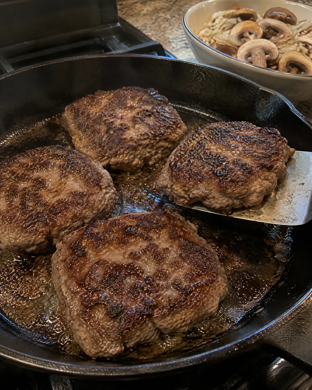 Browned ground beef steaks in a skillet