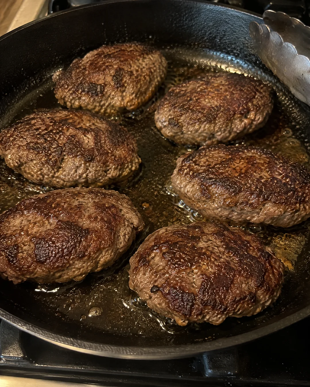 Beef patties browning in a skillet before the gravy is made