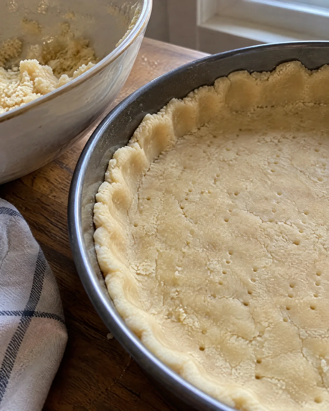 Shortbread dough like damp sand being pressed into a round pan
