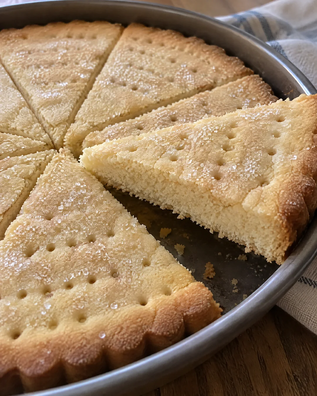 A round of pale Scottish shortbread cut into petticoat tails in the pan