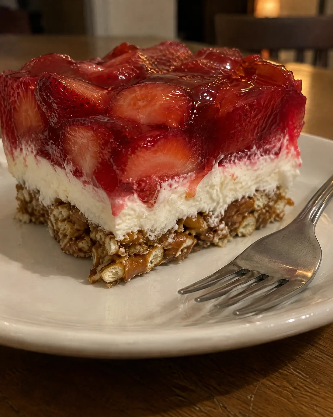 A square of strawberry pretzel salad showing the three layers from the side