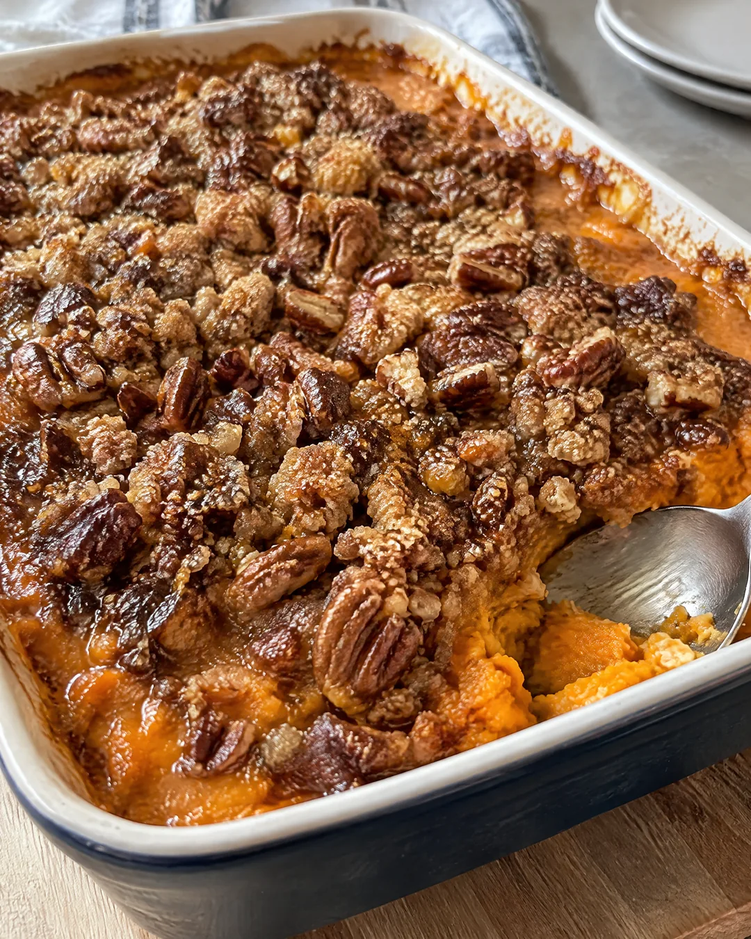 Sweet potato casserole with crunchy pecan crumble topping in a baking dish