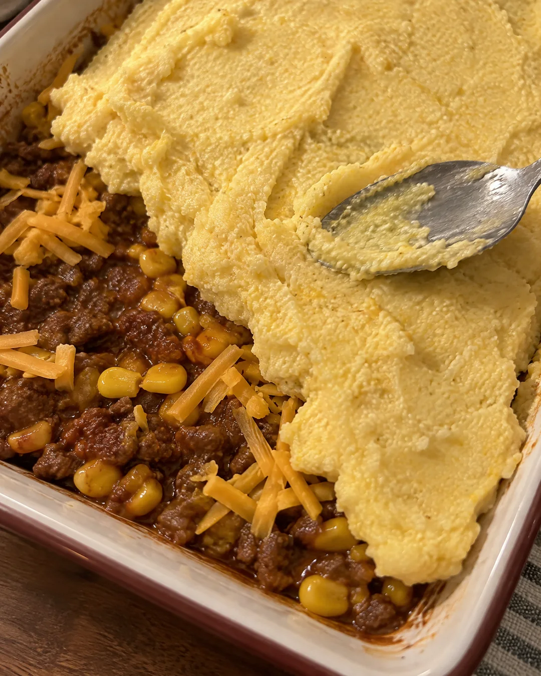 Stiff cornmeal batter smoothed with the back of a spoon over the cheese and ground beef filling in a 9 by 13 inch baking dish
