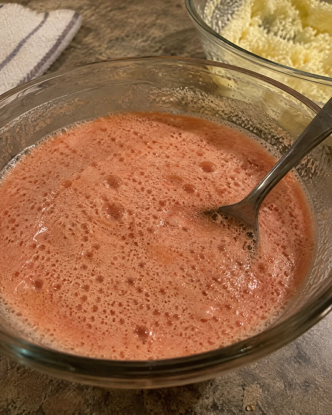 Condensed tomato soup foaming up pink and thick in a bowl after the baking soda is stirred in